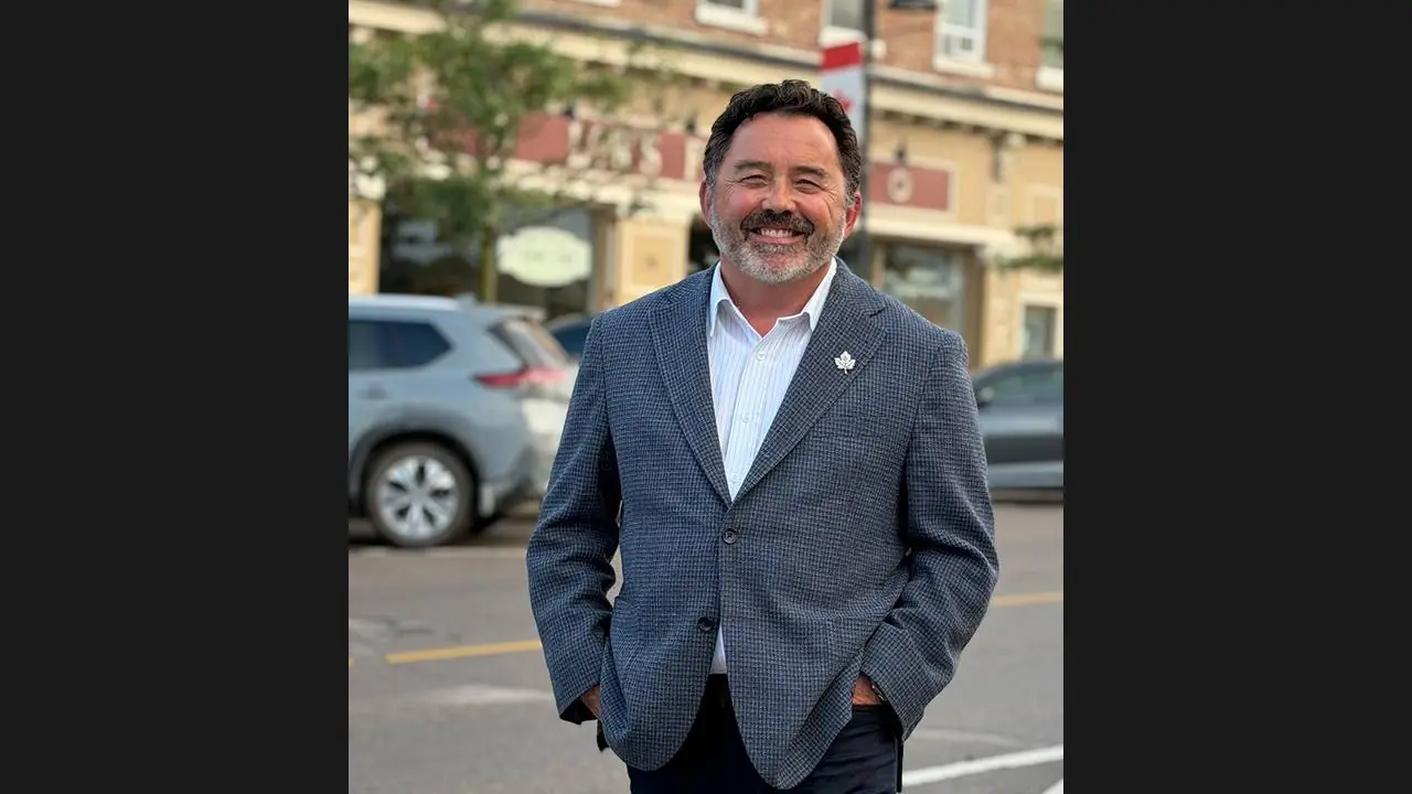 Uxbridge mayor Dave Barton, smiling in a blazer on a downtown street in his campaign photo.