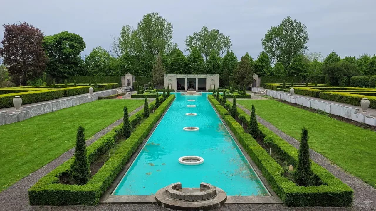 The formal garden at Parkwood Estate in Oshawa, with a long reflecting pool, trimmed hedges and lawns; no people visible.