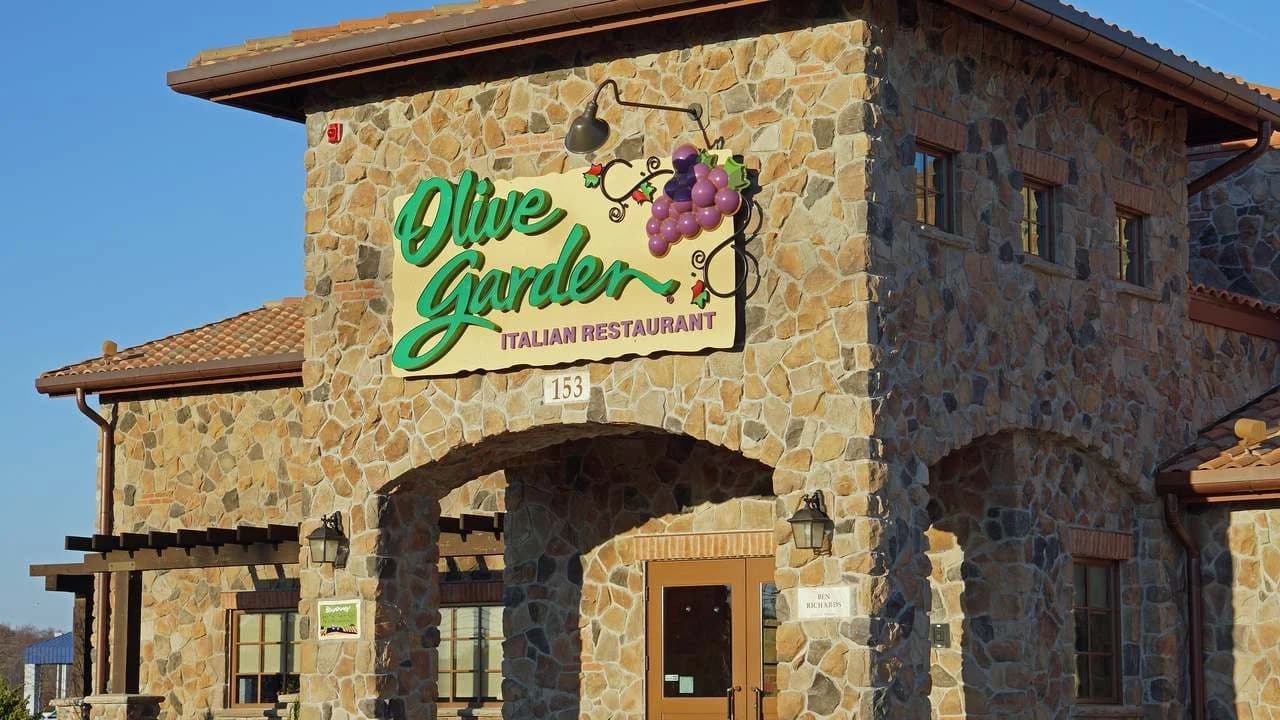 Exterior of an Olive Garden Italian restaurant with its sign on a stone facade; file photo, no people visible.