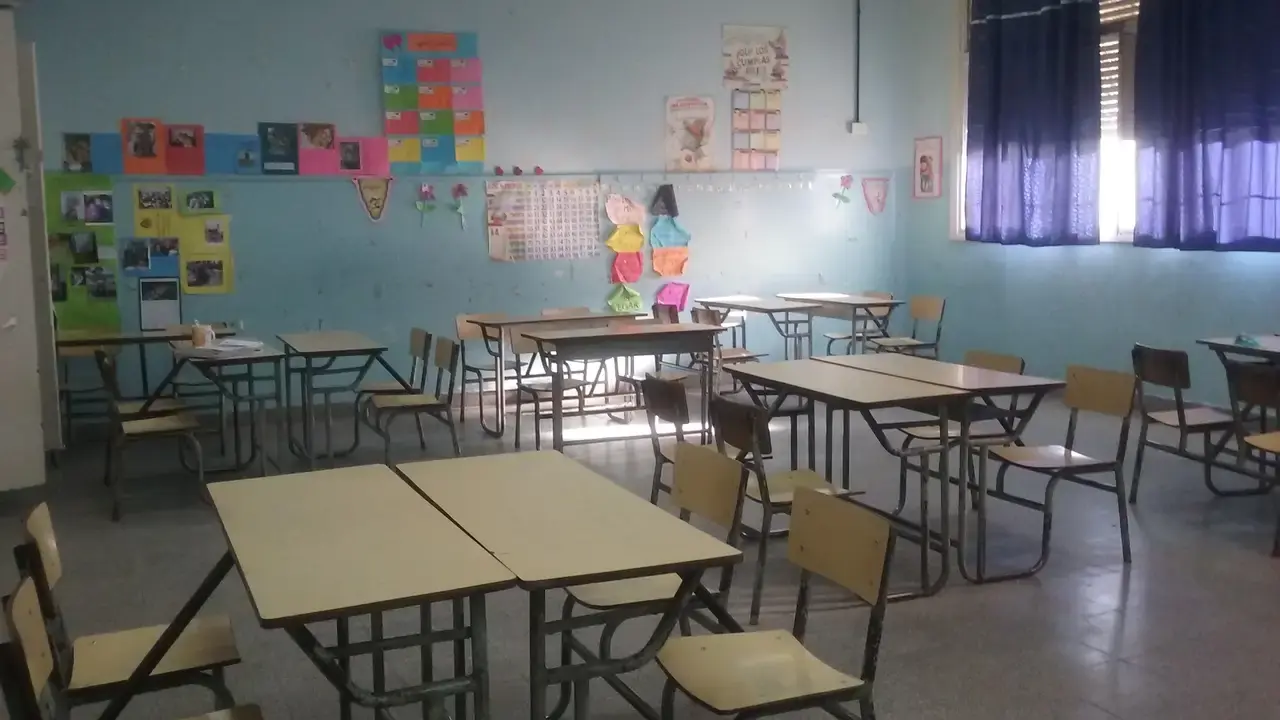 An empty elementary classroom with desks and chairs and colourful wall displays; no people visible. File photo, not the future Oshawa Whitelaw school.