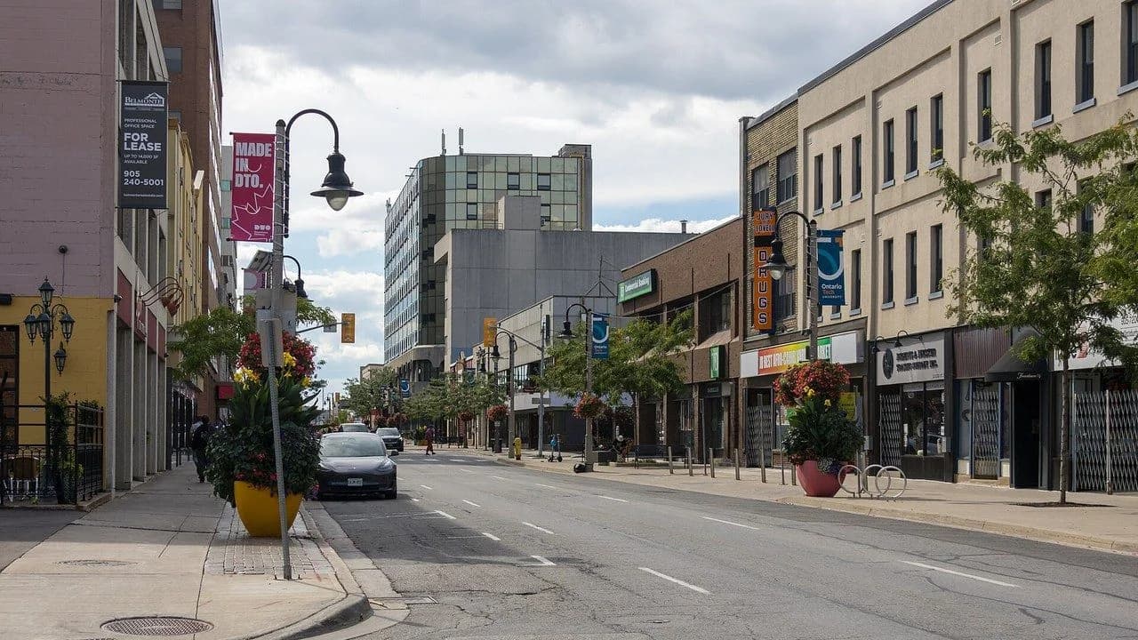 King Street in downtown Oshawa with shops and storefronts on a sunny day; no people visible