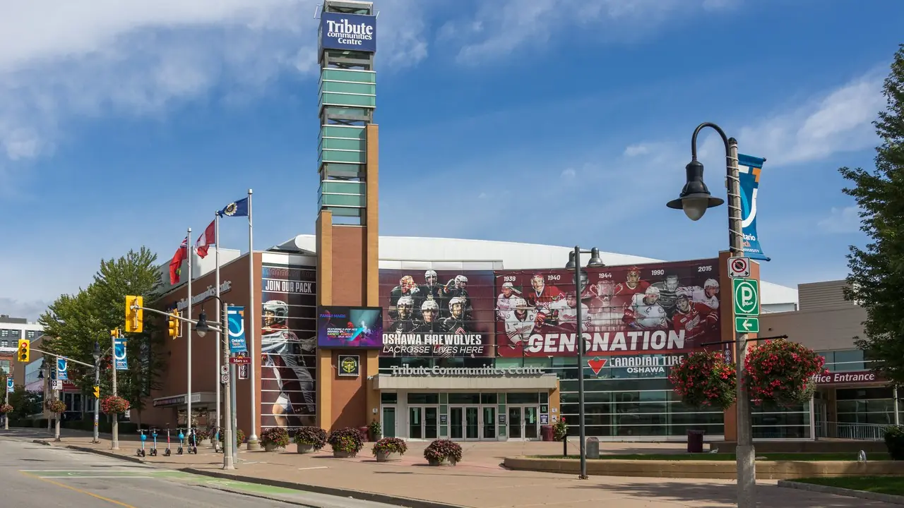 Daytime exterior of the Tribute Communities Centre arena in Oshawa, Ontario, home of the Oshawa Generals, with the venue's name on the entrance tower
