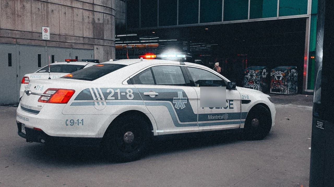 Police cruiser with flashing emergency lights parked on a city street.