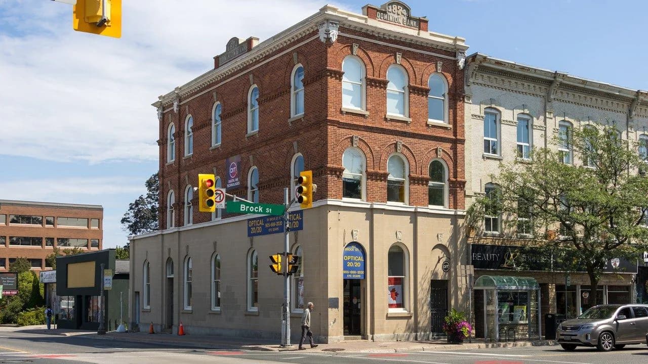 The historic Dominion Bank Building at Brock Street in downtown Whitby, brick heritage facade with ground-floor storefronts, no identifiable people